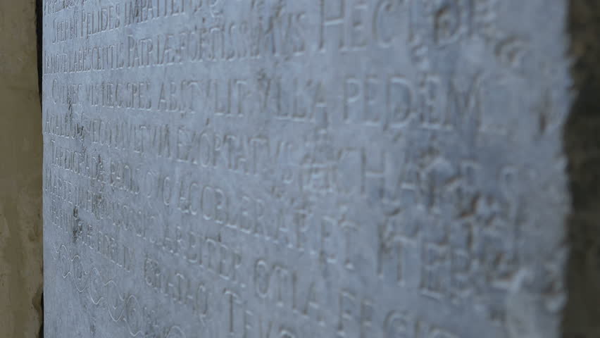 Shifting focus along an ancient Latin language stone engraved text.