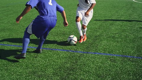 OREGON, USA, JULY 2015: A soccer player dribbles down the field as an opponent defends him, and he shoots and makes a goal