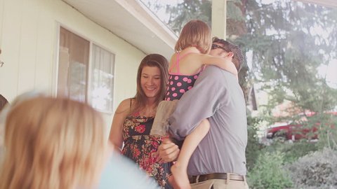 Three sisters excitedly greet their dad when he gets home from work