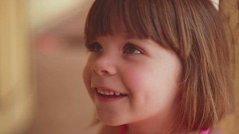 Close up of an adorable little girl smiling and looking up at someone