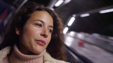 4k Young, attractive woman going down an escalator on the subway underground. Shot on RED Epic.