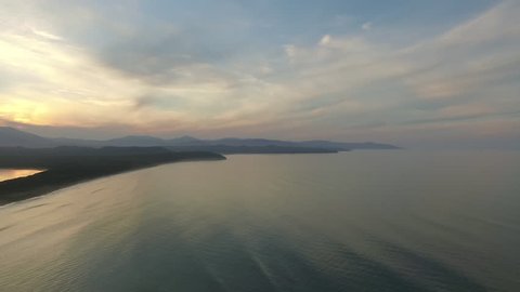 view from bird flight over the ocean and the island of Sakhalin. on the sunset