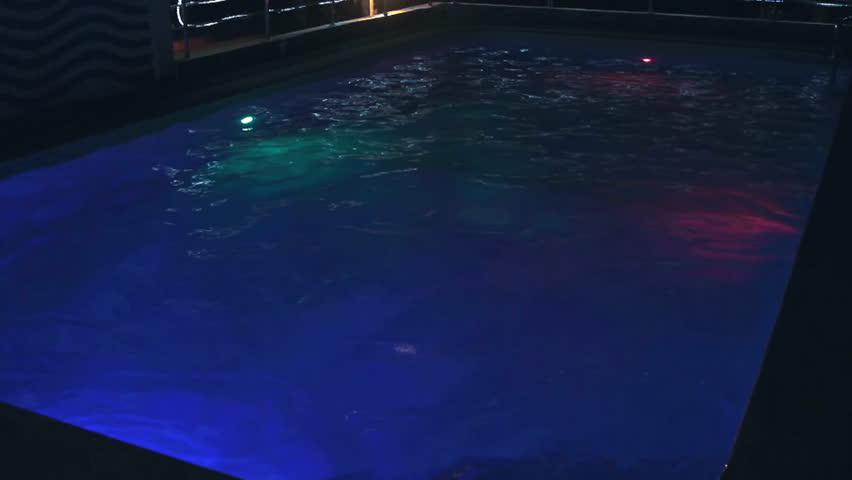 Young man in the Swimming Pool at Night