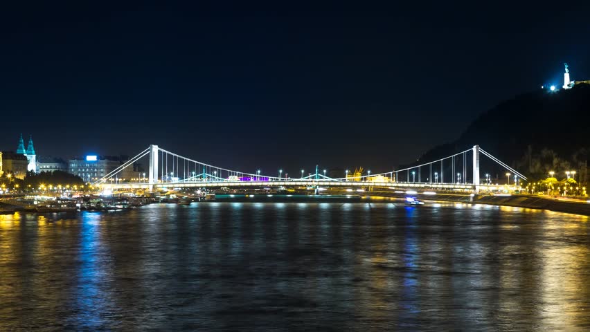 4K Night Time Lapse scene of the Elizabeth bridge in Budapest with boat traffic on Danube river filmed from the Chain Bridge. 