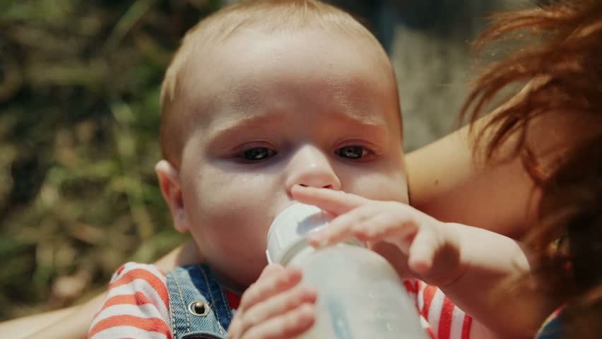 Mother feeding her Baby in nature outdoors in the Park
