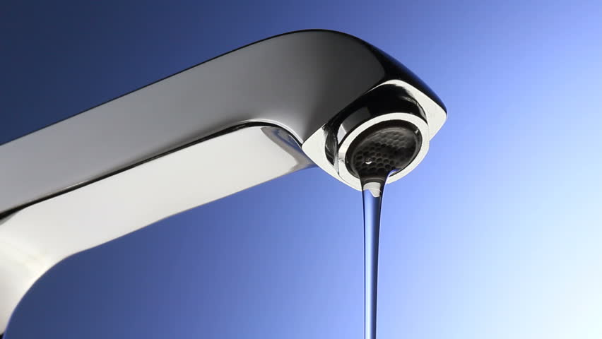 A chrome shiny faucet with running water slows to a drip and then stops. 