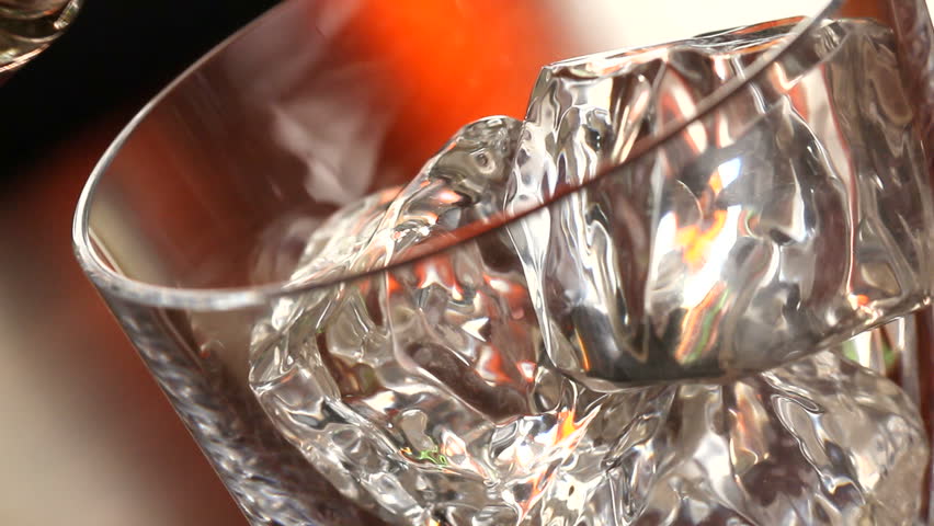 Pouring a scotch whiskey on the rocks close up