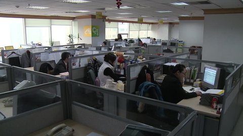 Chengdu, China - March 2010: A modern Chinese office with workers at their computers in cubicles in Chengdu, China.