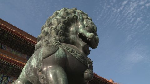 Forbidden City, Beijing - July 2010: A bronze lion statue, against a blue sky, in front of the Gate of Supreme Harmony in the Forbidden City, Beijing, China.