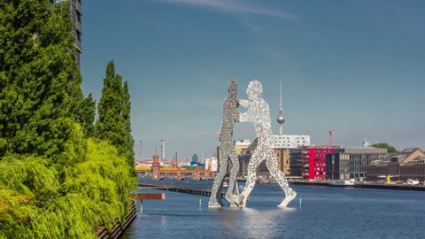 BERLIN, GERMANY - JULY 16, 2013: Skyline of Berlin and the sculpture "Molecular men" in the foreground and the river Spree, Berlin, Germany. Timelapse, hyperlapse view 4K.