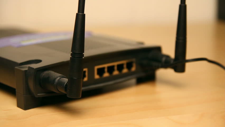 Plugging in network cables to a wireless router.