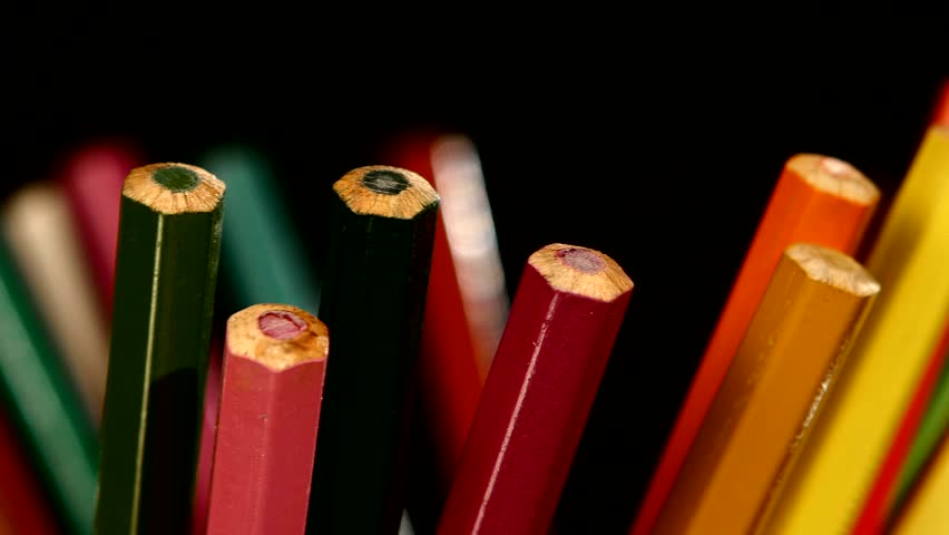 Bottom of lot of different colour pencils on black background, rotation, clsoe up