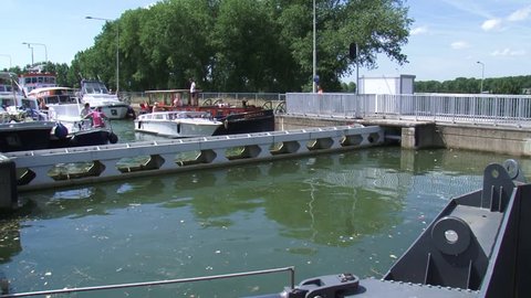LOCK COMPLEX MAASBRACHT, THE NETHERLANDS - AUGUST 2015: Recreational vessels in lock chamber filled with water, waiting for the water level to decrease.