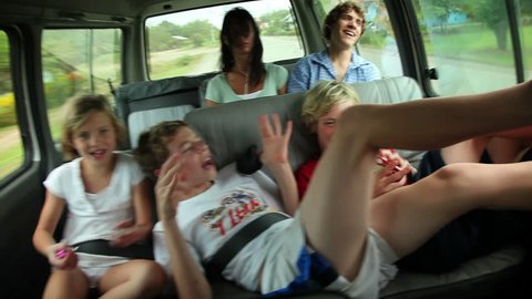 Siblings playing in the back of a van while traveling