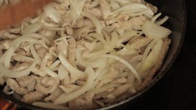 Cook roasts meat with onions in a pan