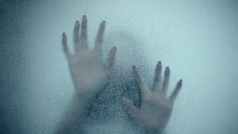 female hand and head, spooky shadows on the glass wall, in full HD, Horror movie scene