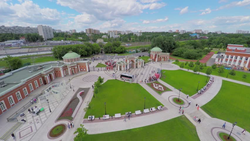 People walk near entrance gate to territory of Tsaritsino park at summer sunny day. Aerial view