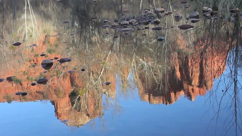 Red rock formations shimmer in creek waters in Sedona, Arizona. 1080p