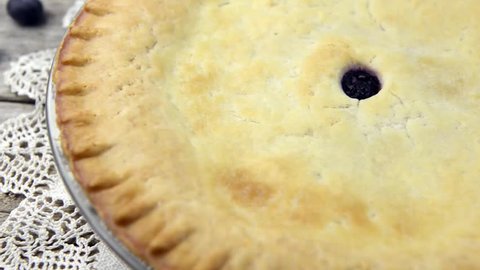 Tracking dolly shot of freshly baked blueberry pie on rustic wooden background : vidéo de stock