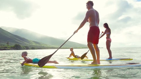 Family Stand Up Paddling at Sunrise. Summer Fun Family Vacation Healthy Lifestyle. Learning to Surf. SUP.