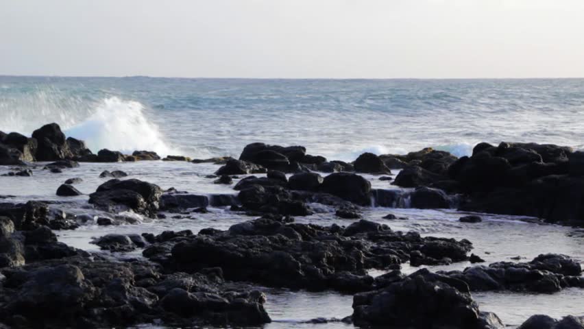 Ocean waves crash on the shore of Kauai, Hawaii