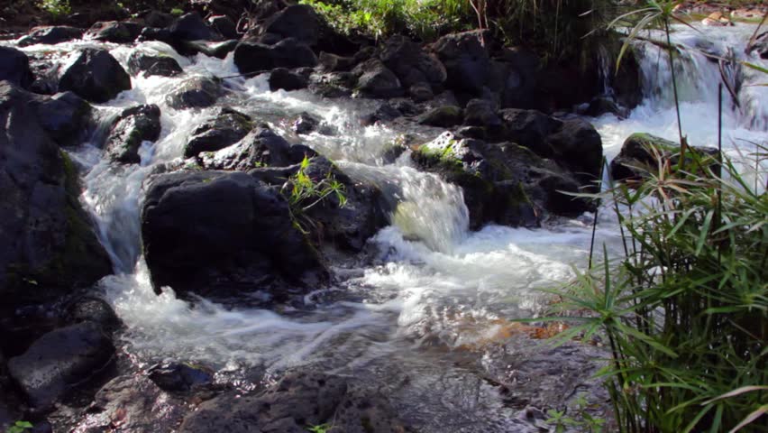 A clear mountain stream with a waterfall