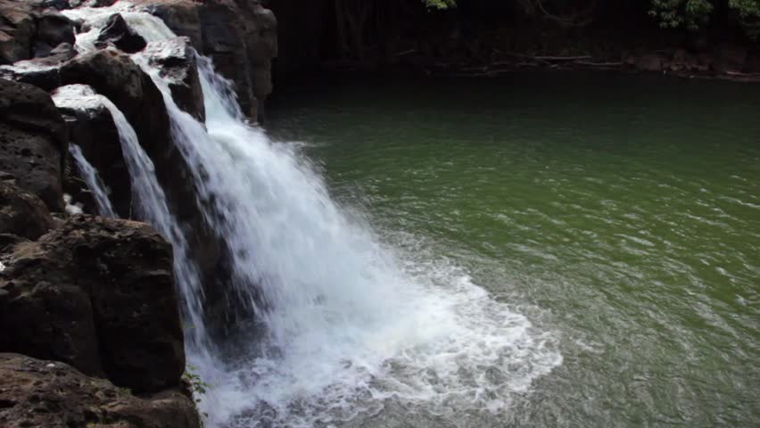 A waterfall cascades into a lagoon