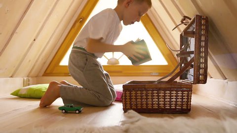 Boy's discovering the contents of the chest with toys in the attic