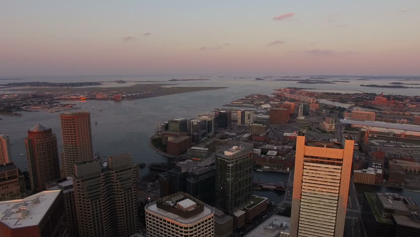 Boston Aerial v60 Flying over downtown at sunset with cityscape and airport views.
