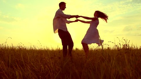 Happy couple having fun outdoor. Young man and woman spinning and laughing. Excited with the freedom of the countryside. Nature. Freedom concept. Slow motion 1080p full hd. High speed camera shot 