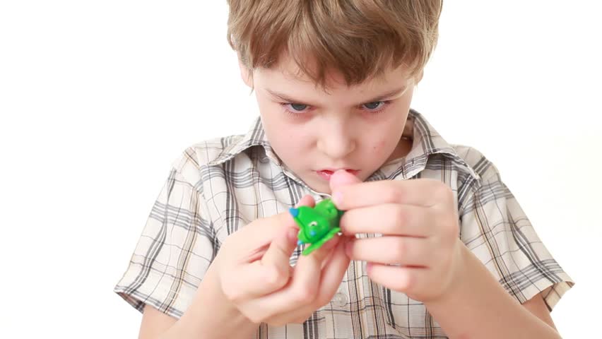 The boy trying to add green toy last part and it seems like he did it