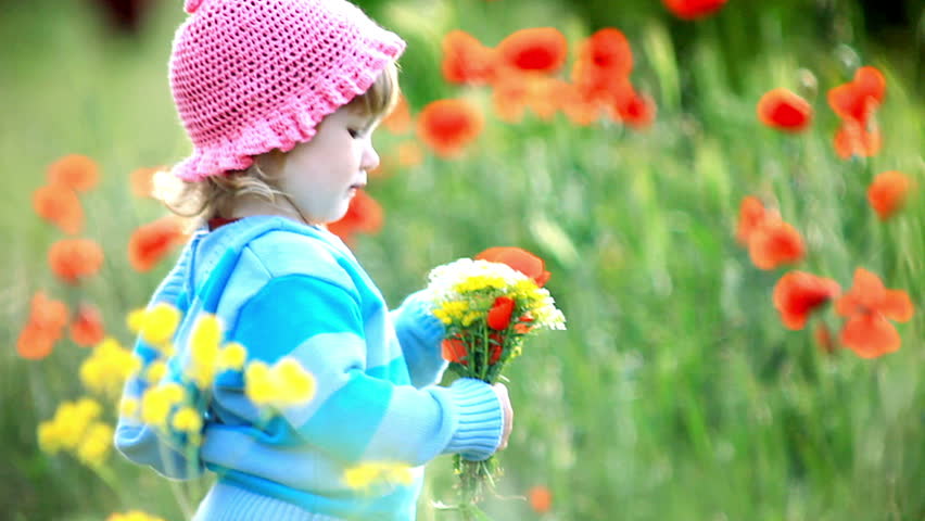Beautiful child with flowers in her hands. She looks at camera
