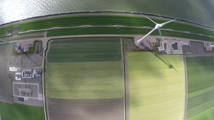Aerial of wind turbine view from above top down bird eye view on green grass land near sea providing wind energy green energy renewable energy showing mast and blades aerofoil-powered wind park 4k Royalty-Free Stock Footage #11565050