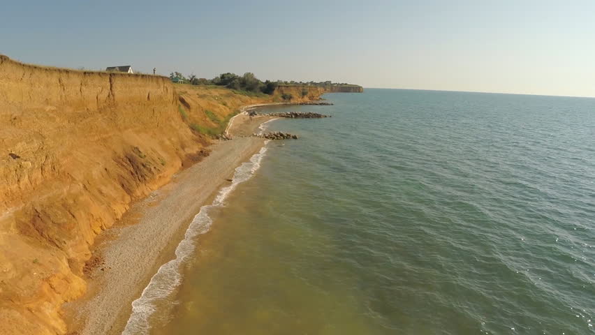 flying camera shooting over the water and near rocks
