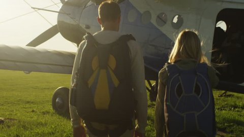 Man and Girl with Parachutes Moving out of the Plane. Shot on RED Cinema Camera in 4K (UHD).
