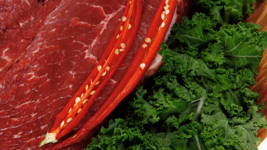 fresh raw beef meat fillet with red hot chili pepper and raw kale leafs on wooden board 1920x1080 intro motion slow hidef hd