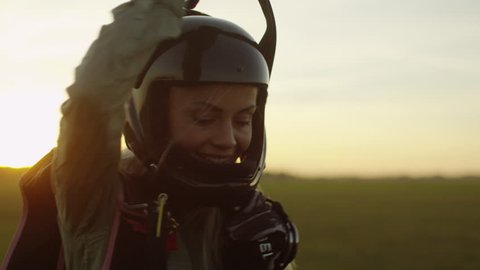 Girl Skydiver in Helmet is Picking Up Parachute after Successful Landing. Shot on RED Cinema Camera in 4K (UHD).