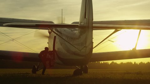 Skydiver is Getting in Propeller Airplane in Sunset Light. Shot on RED Cinema Camera in 4K (UHD).
