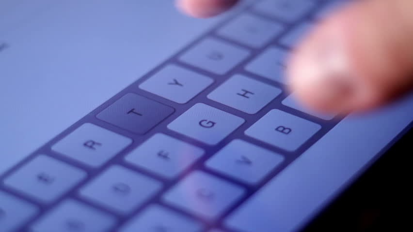 Typing an email on a touchscreen keyboard on a tablet pc.  Close-up.  Shallow