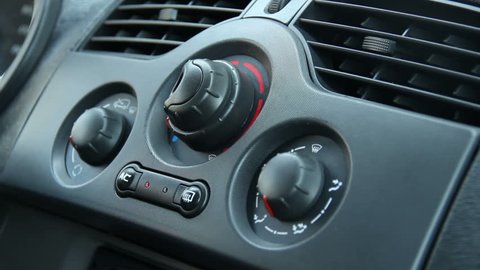 Closeup of Male Turning Heater Switches on Car Defroster
