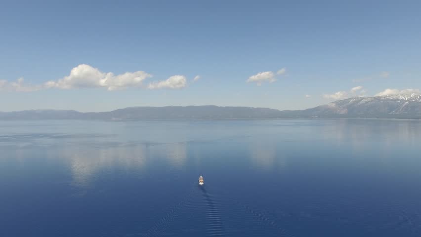 Flying looking at a riverboat on Lake Tahoe and rotating 180 degrees CW and traveling toward the bank.