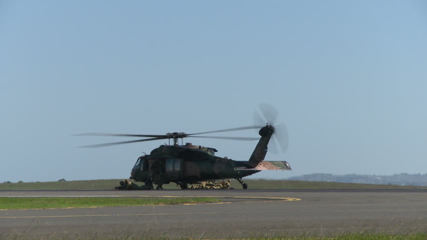 A blackhawk military helicopter takes off after dropping off a squad of