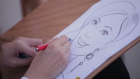 artist paints a portrait caricature of a woman, close up