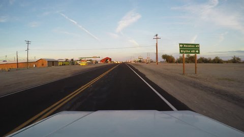 PARKER STRIP, AZ/USA - June 16, 2015: Vehicle viewpoint of driving in a small town on the California and Arizona border. A traveler goes through a small rural community city and stops at a stop sign.