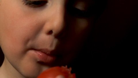 child eating a tomato