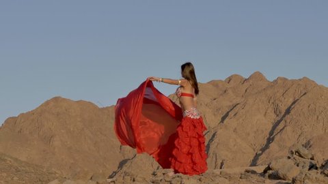 Beautiful girl dancing ethnic dances in desert