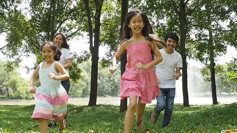 Asian family running together in the park