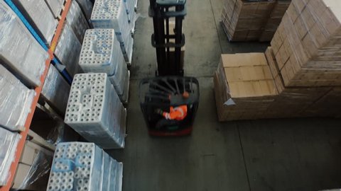 Aerial Overhead Shot of Working Forklift Loader inside Logistic Warehouse. Shot in 4K (UHD).