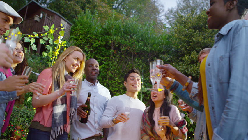 4K Happy mixed ethnicity friends raise their glasses for a toast at outdoor social gathering. Shot on RED Epic.