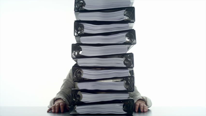 An Hispanic woman behind a stack of binders 